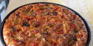 Ψημένη νηστίσιμη λαδένια σε ταψί, με πλούσια επικάλυψη από ντομάτα, κρεμμύδι και ελιές, έτοιμη για σερβίρισμα.