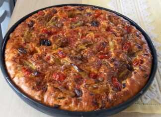 Ψημένη νηστίσιμη λαδένια σε ταψί, με πλούσια επικάλυψη από ντομάτα, κρεμμύδι και ελιές, έτοιμη για σερβίρισμα.