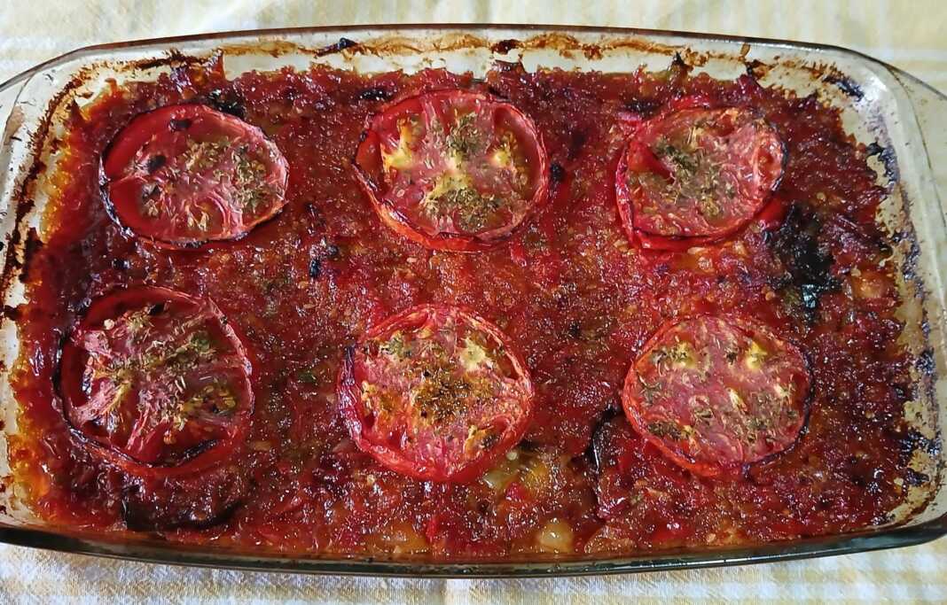 melitzanes me revithia Ένα ταψί με Μελιτζάνες με ρεβίθια, έτοιμο για ψήσιμο, με τη σάλτσα από πάνω και τις ροδέλες ντομάτας.