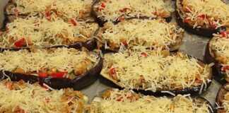 Ψητές μελιτζάνες φούρνου με ντομάτα και τυρί, με λιωμένη μοτσαρέλα και βασιλικό, έτοιμες για σερβίρισμα σε ένα ταψί