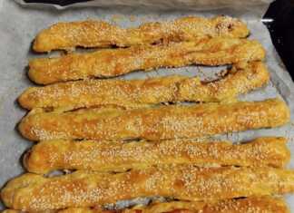 Ταψί με Σφολιατίνια με τυρί και μπέικον, έτοιμα για ψήσιμο, αλειμμένα με αυγό και πασπαλισμένα με σουσάμι