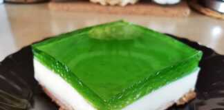 Γλυκό Ψυγείου: Το διαχρονικό γλυκό με μπισκότα, κρέμα και ζελέ! Ένα κομμάτι γλυκό ψυγείου, που φαίνονται καθαρά οι τρεις στρώσεις: μπισκότα, κρέμα και ζελέ