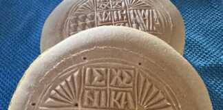 Ένα ολόκληρο, ψημένο πρόσφορο με τη σφραγίδα του, πάνω σε ξύλινο τραπέζι