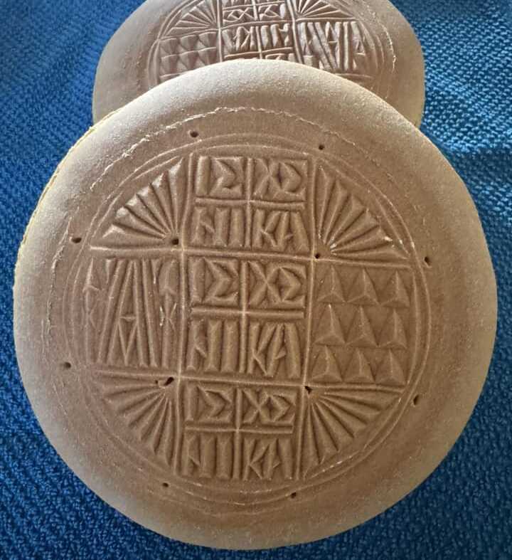 prosforo iero psomi Ένα ολόκληρο, ψημένο πρόσφορο με τη σφραγίδα του, πάνω σε ξύλινο τραπέζι