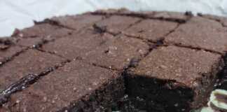 Ένα ολόκληρο σοκολατένιο κέικ μπεν μαρί σερβιρισμένο σε δίσκο, με γλάσο σοκολάτας