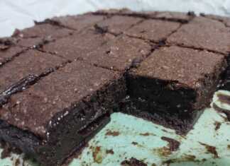 Ένα ολόκληρο σοκολατένιο κέικ μπεν μαρί σερβιρισμένο σε δίσκο, με γλάσο σοκολάτας