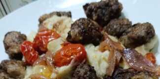 Ζουμερά τηγανιτά συκωτάκια σε πιάτο, συνοδευόμενα από καραμελωμένα κρεμμύδια και ντοματίνια.