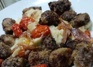 Ζουμερά τηγανιτά συκωτάκια σε πιάτο, συνοδευόμενα από καραμελωμένα κρεμμύδια και ντοματίνια.