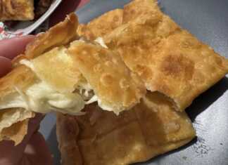 Κοντινό πλάνο σε ένα τυροπιτάκι Γκιουζλεμές, που αναδεικνύει την πλούσια γέμιση φέτας που βρίσκεται στο εσωτερικό του