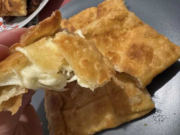 tiropitaria evoias Κοντινό πλάνο σε ένα τυροπιτάκι Γκιουζλεμές, που αναδεικνύει την πλούσια γέμιση φέτας που βρίσκεται στο εσωτερικό του