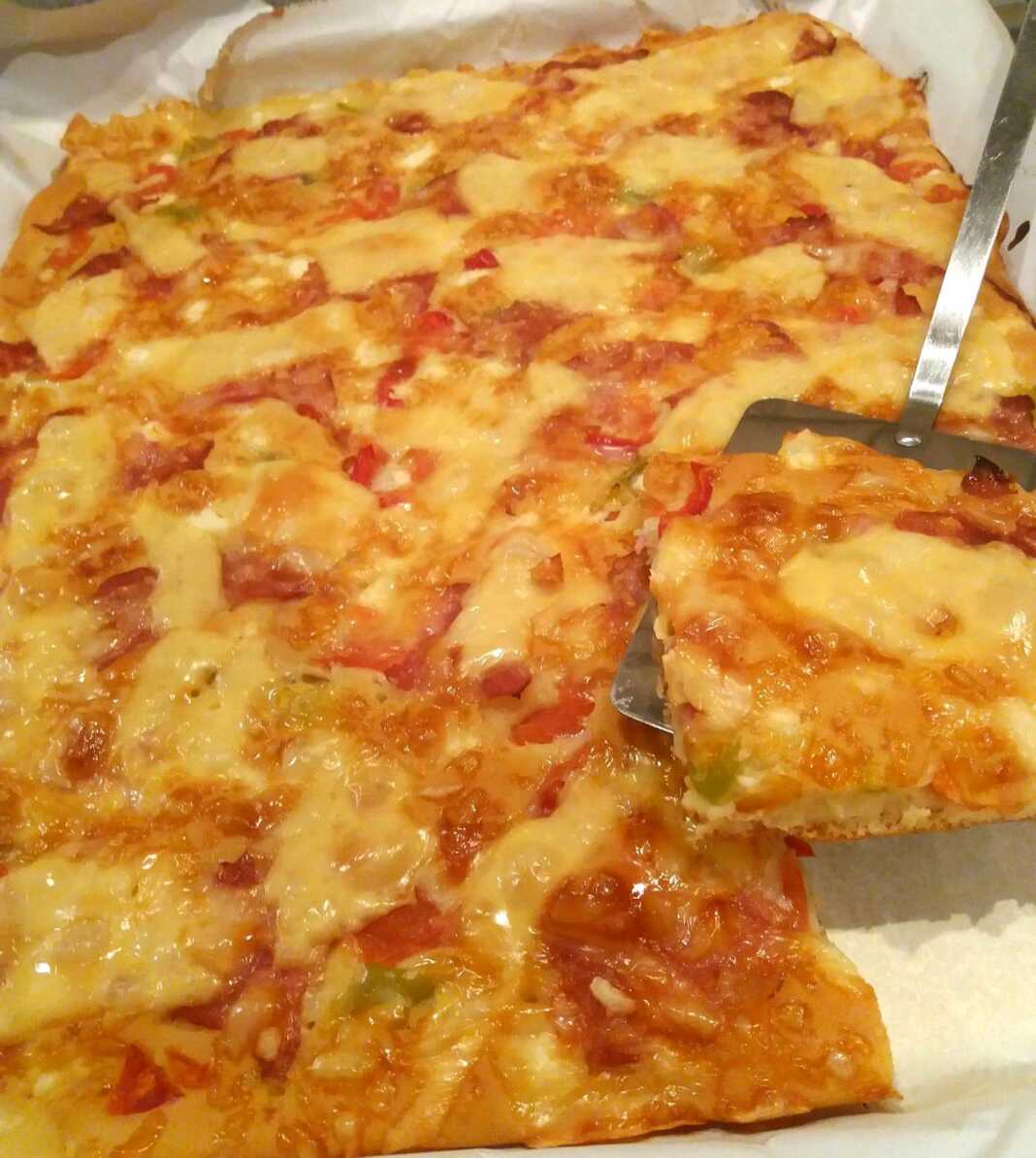 Μια ολόκληρη ζυμαρόπιτα πίτσα, ψημένη, με πλούσια υλικά και χρυσαφένιο χρώμα