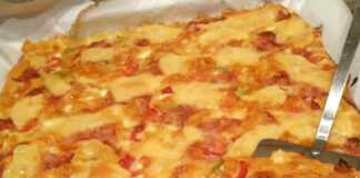 Μια ολόκληρη ζυμαρόπιτα πίτσα, ψημένη, με πλούσια υλικά και χρυσαφένιο χρώμα