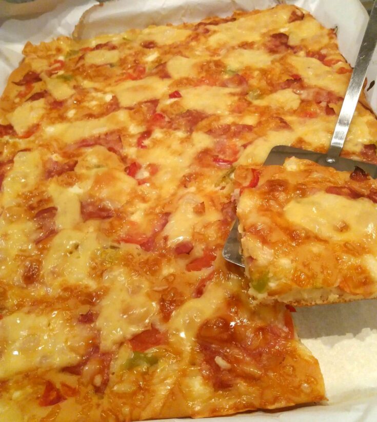 Μια ολόκληρη ζυμαρόπιτα πίτσα, ψημένη, με πλούσια υλικά και χρυσαφένιο χρώμα