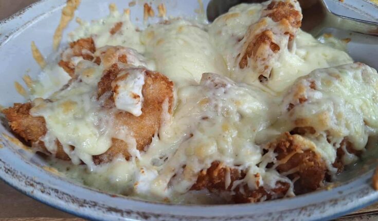 Ένα ζουμερό πιάτο με κοτόπουλο με τυρί, βγαλμένο μόλις από τον φούρνο, με το τυρί να λιώνει