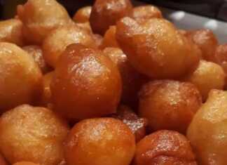 Μια πιατέλα γεμάτη με χρυσαφένιους, σιροπιαστούς παραδοσιακούς λουκουμάδες, περιχυμένους με μέλι.