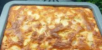 Το κέικ μηλόπιτα μέσα στο ταψί, βγαλμένο μόλις από τον φούρνο με χρυσαφένια επιφάνεια