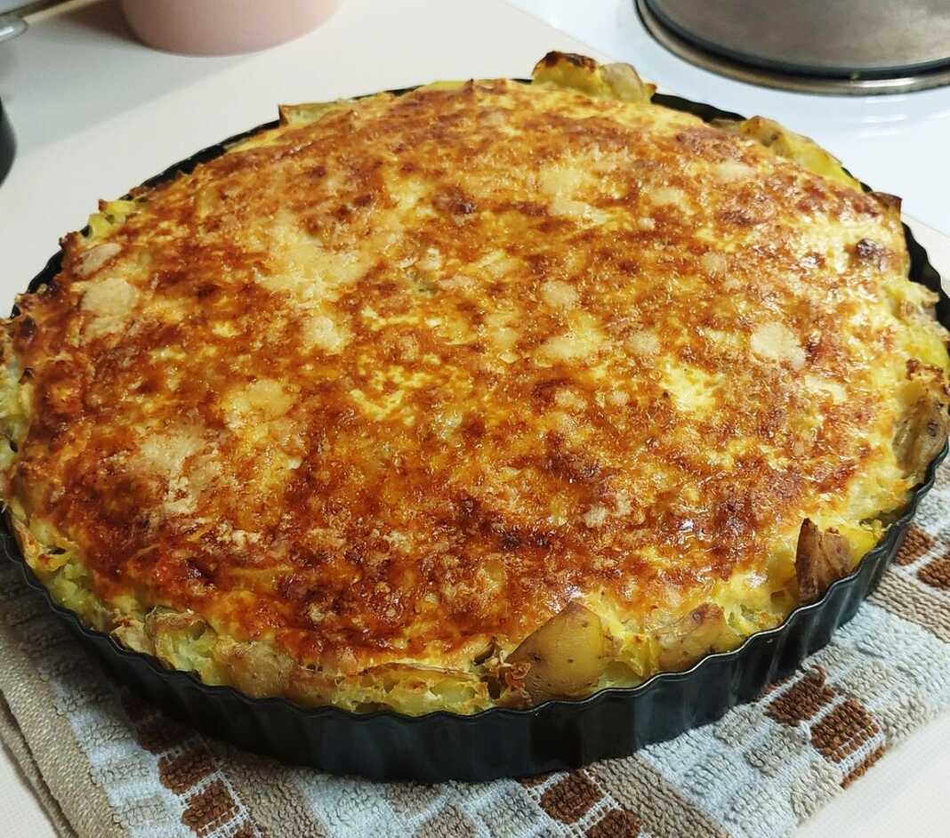 Μια ολόκληρη αλμυρή τάρτα πατάτας με τυριά και μανιτάρια, σερβιρισμένη σε πιατέλα