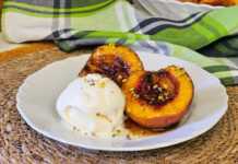 Μια πιατέλα με ζεστά ψητά ροδάκινα με καστανή ζάχαρη και μια μπάλα παγωτό βανίλια