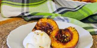 Μια πιατέλα με ζεστά ψητά ροδάκινα με καστανή ζάχαρη και μια μπάλα παγωτό βανίλια