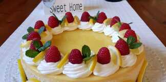 Ένα ολόκληρο cheesecake με λιμοντσέλο, με το κίτρινο lemon curd από πάνω, σε ένα τραπέζι