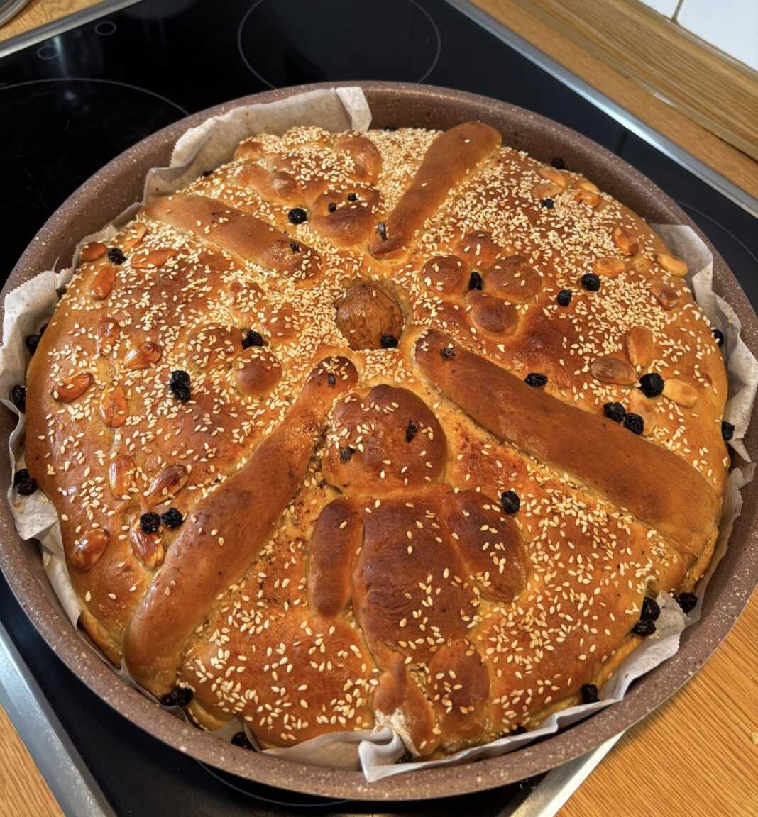 christopsomo Ένα ολόκληρο, παραδοσιακό Χριστόψωμο με περίτεχνο στόλισμα, πάνω σε μια ξύλινη επιφάνεια