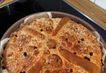 Ένα ολόκληρο, παραδοσιακό Χριστόψωμο με περίτεχνο στόλισμα, πάνω σε μια ξύλινη επιφάνεια