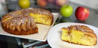 Μια ολόκληρη αφράτη μηλόπιτα με κομμάτια μήλου και πασπαλισμένη κανέλα, σε φόρμα.