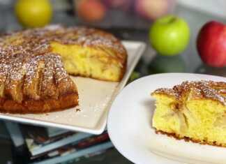 Μια ολόκληρη αφράτη μηλόπιτα με κομμάτια μήλου και πασπαλισμένη κανέλα, σε φόρμα.