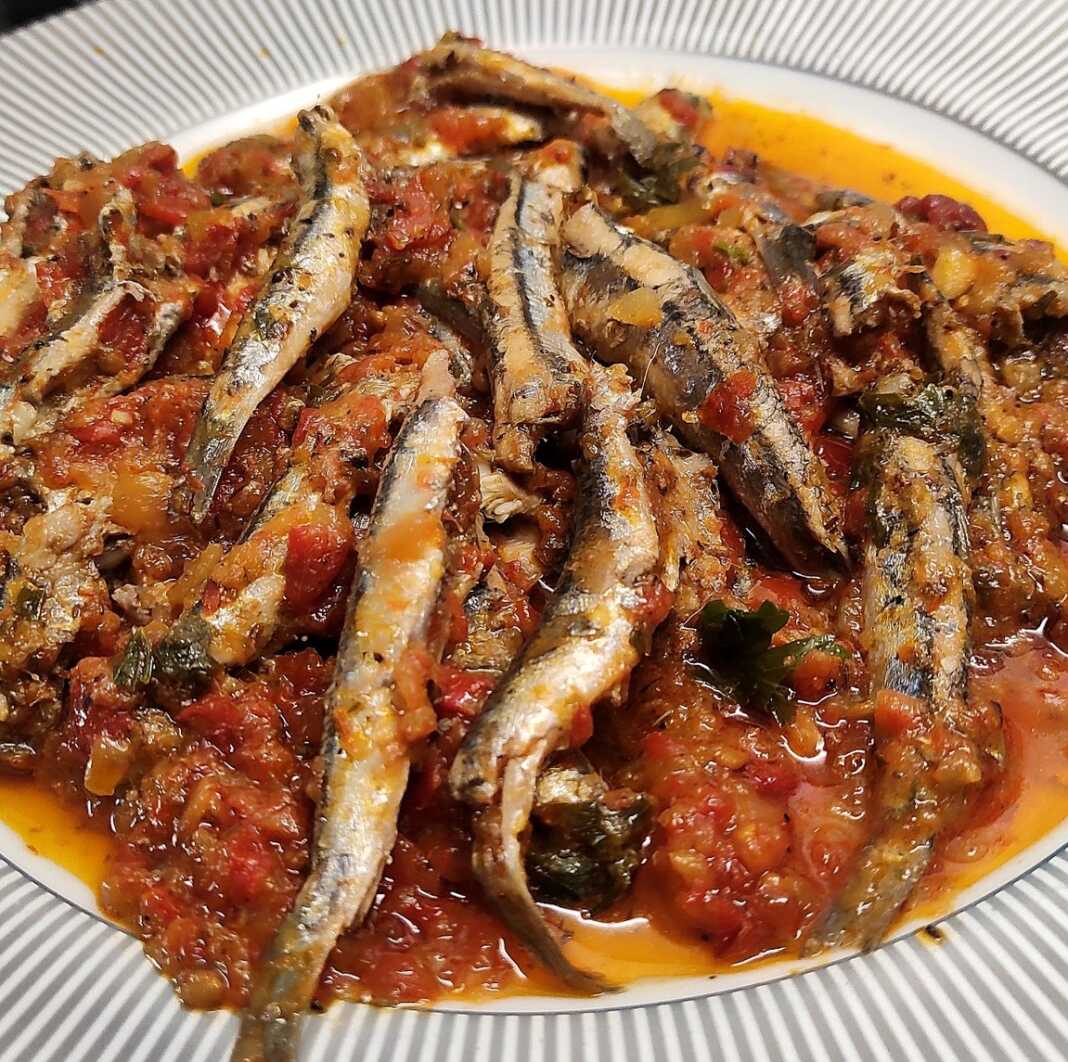 gavros ntomata Μια πιατέλα με τηγανητό γαύρο με σάλτσα ντομάτας, πασπαλισμένο με φρέσκο μαϊντανό