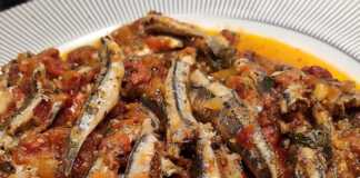 Μια πιατέλα με τηγανητό γαύρο με σάλτσα ντομάτας, πασπαλισμένο με φρέσκο μαϊντανό