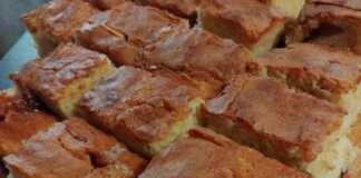 Ένα ολόκληρο κέικ σε κομματια με γιαούρτι, ψημένο μέχρι να ροδίσει, πάνω σε μια βάσ