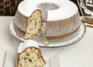 Ένα ολόκληρο, φρεσκοψημένο σχολικό μαμαδίστικο κέικ με ζάχαρη άχνη, σε πιατέλα.