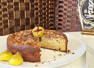 Ένα ολόκληρο κέικ με σύκα, διακοσμημένο με κομμάτια σύκου και αμύγδαλα.