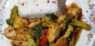 Ένα μπολ με κοτόπουλο stir-fry με λαχανικά και σάλτσα σόγιας, σερβιρισμένο πάνω σε ρύζι μπασμάτι