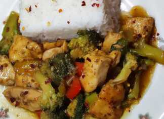 Ένα μπολ με κοτόπουλο stir-fry με λαχανικά και σάλτσα σόγιας, σερβιρισμένο πάνω σε ρύζι μπασμάτι