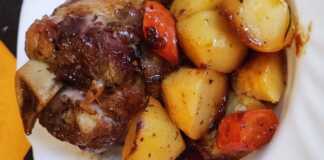 Ένα ζουμερό χοιρινό κότσι στη γάστρα με ροδοκοκκινισμένες πατάτες, έτοιμο για σερβίρισμα