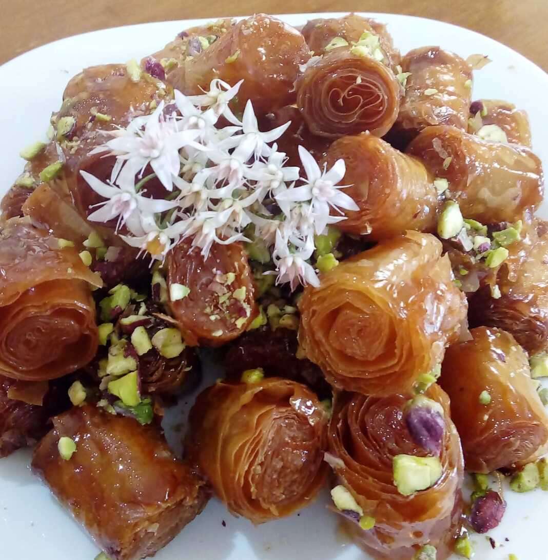 Μια πιατέλα με σιροπιαστά κουρκουμπίνια με μέλι, πασπαλισμένα με τριμμένα φιστίκια.