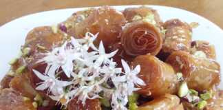 Μια πιατέλα με σιροπιαστά κουρκουμπίνια με μέλι, πασπαλισμένα με τριμμένα φιστίκια.