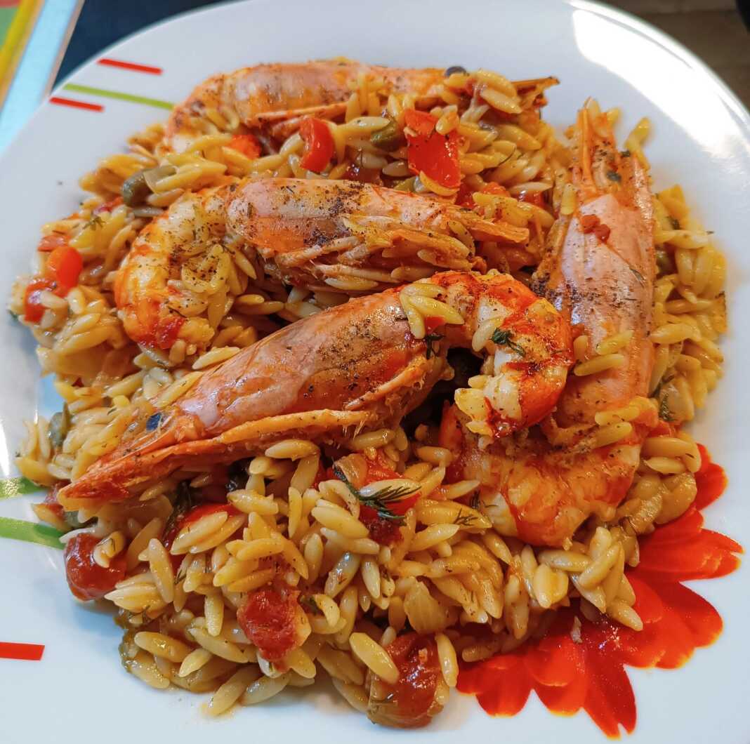 kritharoto me garides Μια κοντινή φωτογραφία από ένα πιάτο με ζεστό, λαχταριστό κριθαρωτό με γαρίδες και λαχανικά