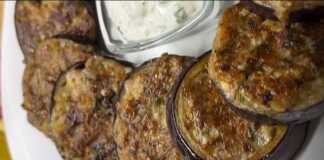 Ένα πιάτο με ορεκτικό μελιτζάνας και μια μικρή κούπα με τη σάλτσα γιαουρτιού