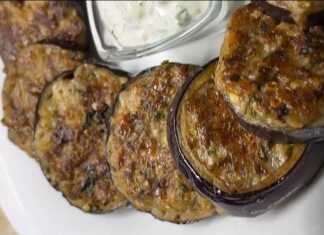 Ένα πιάτο με ορεκτικό μελιτζάνας και μια μικρή κούπα με τη σάλτσα γιαουρτιού