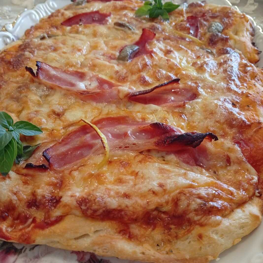 Μια λαχταριστή σπιτική πίτσα με δικό μου ζυμάρι, φρεσκοψημένη σε ένα ταψί, με μπέικον