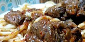 Προβατίνα κοκκινιστή με χοντρά μακαρόνια σε πιάτο, με την πλούσια σάλτσα