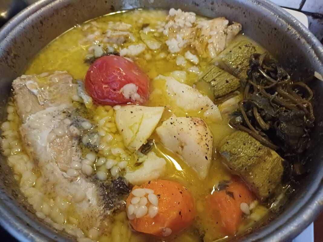 Μια κατσαρόλα με βρασμένα λαχανικά και φιλέτο μπακαλιάρου για ψαρόσουπα