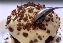 Το έτοιμο σοκολατένιο κέικ χωρίς αλεύρι μέσα σε κούπα, με την επικάλυψη γιαουρτιού και σοκολάτας.