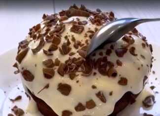 Το έτοιμο σοκολατένιο κέικ χωρίς αλεύρι μέσα σε κούπα, με την επικάλυψη γιαουρτιού και σοκολάτας.