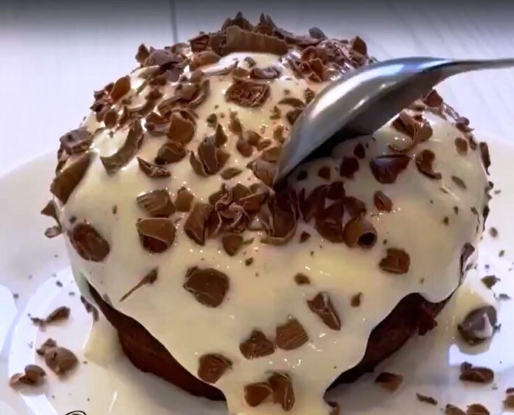 Το έτοιμο σοκολατένιο κέικ χωρίς αλεύρι μέσα σε κούπα, με την επικάλυψη γιαουρτιού και σοκολάτας.