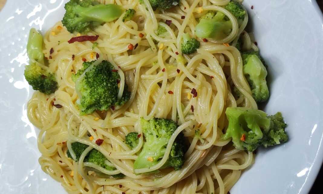 spaggeti me mprokolo kai skordo Ένα μπολ με ζεστό σπαγγέτι με μπρόκολο και σκόρδο, γαρνιρισμένο με φρέσκα μυρωδικά.