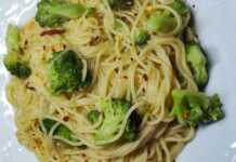 Ένα μπολ με ζεστό σπαγγέτι με μπρόκολο και σκόρδο, γαρνιρισμένο με φρέσκα μυρωδικά.