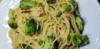 Ένα μπολ με ζεστό σπαγγέτι με μπρόκολο και σκόρδο, γαρνιρισμένο με φρέσκα μυρωδικά.